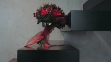 Kırmızı düğün buketi siyah bir merdivende duruyor.