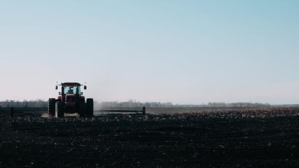 Tractor Campo Primavera Arrastra Tierra Negra Contra Cielo Azul Claro — Vídeo de stock