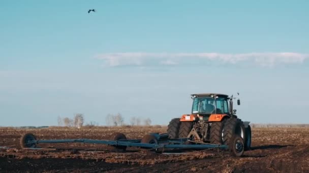 Tractor Campo Primavera Arrastra Tierra Negra Contra Cielo Azul Claro — Vídeos de Stock