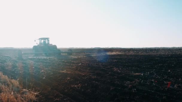 Traktor Ett Fält Våren Drar Svart Jord Mot Klarblå Himmel — Stockvideo