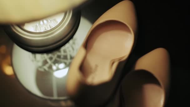Жіноче Взуття Стоїть Скляному Столі Біля Настільної Лампи Відображенням — стокове відео