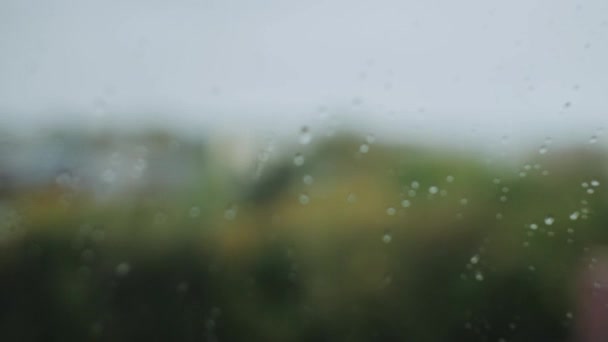 Pohled z okna na podzimní deštivé město na oknech kapek deště
