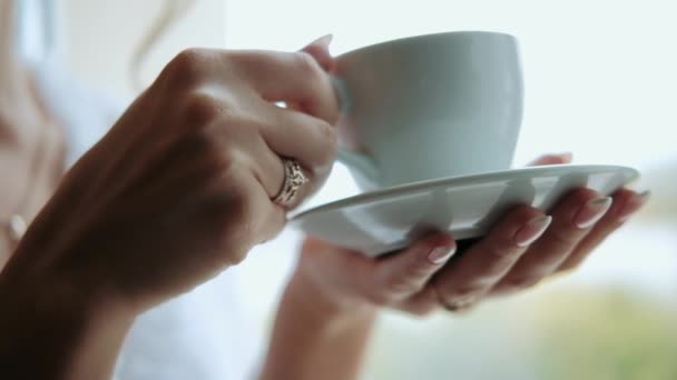 Ragazza Tiene Piattino Con Una Tazza Mentre Beve Caffè — Video Stock