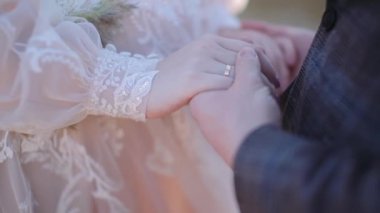 Damat, gelinin avucunu sıkıca tutar.