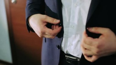 Erkek eli cekete düğme takar.