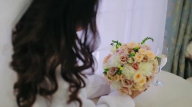 Dişi eller bir buket tutuyor ve çiçeklere yakından dokunuyor.