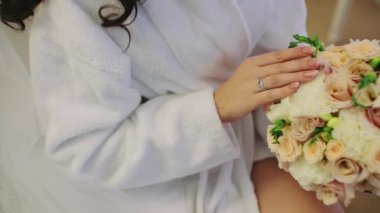 Dişi eller bir buket tutuyor ve çiçeklere yakından dokunuyor.