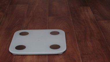 Çıplak ayakla terazide dur. Ağırlık kontrolü. Zayıflayan kız.