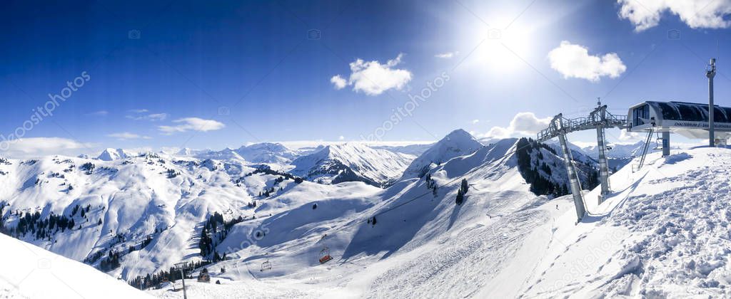 chairlift in front of switerland alps mountain range panorama with blue sky