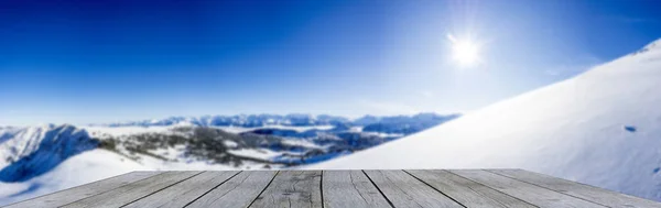 雪の山パノラマに対する木製のディスプレイ棚冬のテーブルトップ青い空 ロイヤリティフリーのストック画像
