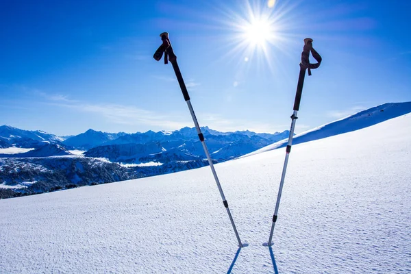 Vintersportkoncept. skidstavar i djup snö mot fjällpanorama med blå himmel — Stockfoto