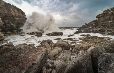 Birkaç kayanın olduğu vahşi bir koy manzarası ve dalgaların okyanusun öfkesini gösteren dalgaların dalgalar üzerindeki etkisi. Doğal manzara, özgürlük havası..