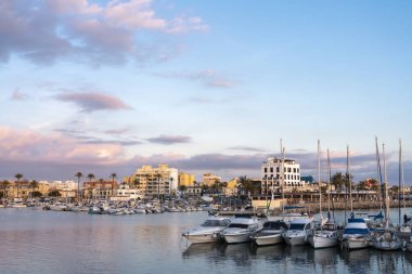 El Portitxol, Palma de Mallorca, Balearics Adaları, İspanya - 28 Aralık 2019: Rıhtımında birkaç tekne ve geleneksel mimarisi bulunan balıkçı köyü Portitxol manzarası. Gün batımında.