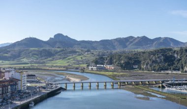 Aerial view landscape of Ribadesella port town, in  Principado de Asturias, Spain. The centered bridge crossing the Sella river and mountains in the background.