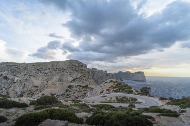 Mallorca, Pollensa sahilindeki Cabo de Formentor deniz fenerine doğru dönen yolun bulutlu manzarası