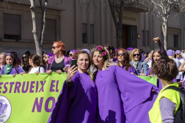 Palma de Mallorca, Spain - March 08, 2020: International Women's Day. Two purple dressed women taking a selfie in the feminist protest.