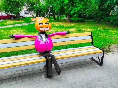 Sarı çizgi film geyiği bankta oturuyor.