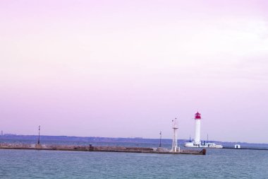 Güzel manzara. Mevcut deniz feneri. Odessa 'daki Vorontsov deniz fenerine karşı Karadeniz' in arka planı, yakın plan. Üzerinde mavi deniz manzaralı kırmızı bir kabin olan beyaz kule.