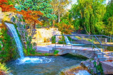 Doğal parktaki nehrin üzerindeki eski taş köprü. Güzel çağlayan şelale 