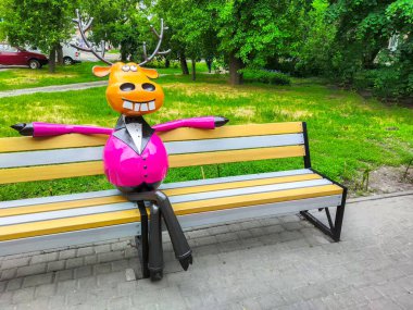 Sarı çizgi film geyiği bankta oturuyor.