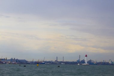Güzel manzara. Mevcut deniz feneri. Odessa 'daki Vorontsov deniz fenerine karşı Karadeniz' in arka planı, yakın plan. Üzerinde mavi deniz manzaralı kırmızı bir kabin olan beyaz kule.