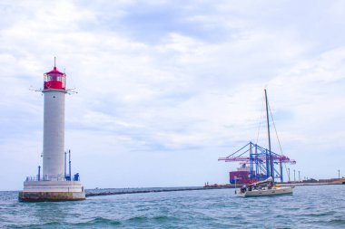 Güzel manzara. Mevcut deniz feneri. Odessa 'daki Vorontsov deniz fenerine karşı Karadeniz' in arka planı, yakın plan. Üzerinde mavi deniz manzaralı kırmızı bir kabin olan beyaz kule.