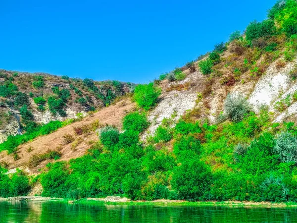 landscape with Dniester river smooth water surface and hill land horizon background in clear summer weather time