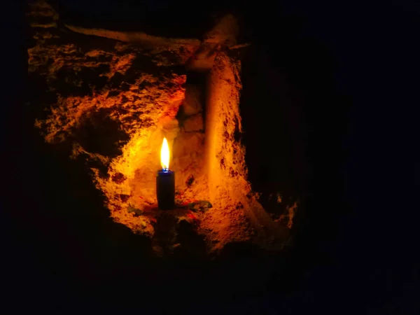在模糊的砖墙背景下燃着的蜡烛 — 图库照片