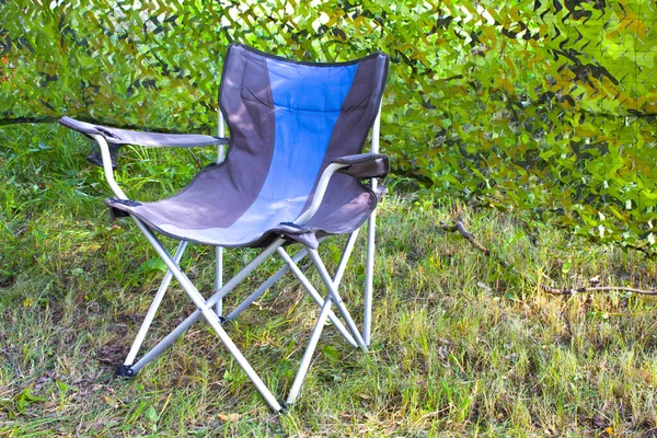 empty camping chair in nature background. Colorful chair and summer camping day.
