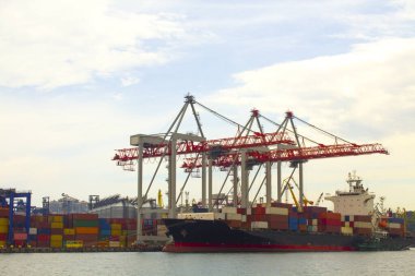 Odessa, Karadeniz 'deki akşam limanında portallar. Denize yanaşmış ağır bir yük gemisi. Arka planda konut ve ticari binalar bulunmaktadır.