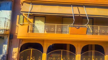 Pencereli sarı bina, dış balkon.