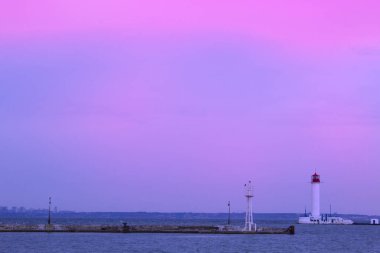 Güzel manzara. Mevcut deniz feneri. Odessa 'daki Vorontsov deniz fenerine karşı Karadeniz' in arka planı, yakın plan. Üzerinde mavi deniz manzaralı kırmızı bir kabin olan beyaz kule.