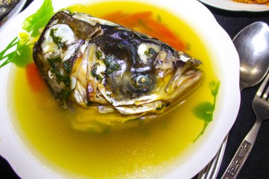 Tabakta balık kafası olan balık çorbası.