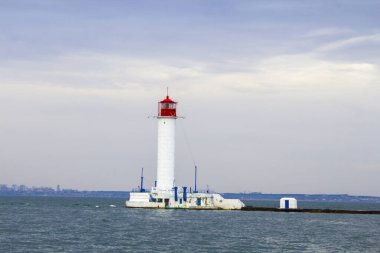Güzel manzara. Mevcut deniz feneri. Odessa 'daki Vorontsov deniz fenerine karşı Karadeniz' in arka planı, yakın plan. Üzerinde mavi deniz manzaralı kırmızı bir kabin olan beyaz kule.