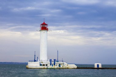 Güzel manzara. Mevcut deniz feneri. Odessa 'daki Vorontsov deniz fenerine karşı Karadeniz' in arka planı, yakın plan. Üzerinde mavi deniz manzaralı kırmızı bir kabin olan beyaz kule.