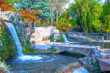 Doğal parktaki nehrin üzerindeki eski taş köprü. Güzel çağlayan şelale 