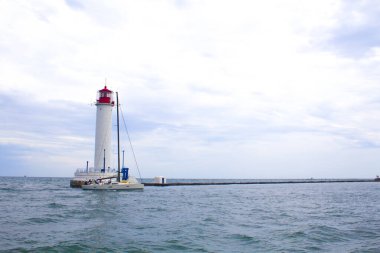 Güzel manzara. Mevcut deniz feneri. Odessa 'daki Vorontsov deniz fenerine karşı Karadeniz' in arka planı, yakın plan. Üzerinde mavi deniz manzaralı kırmızı bir kabin olan beyaz kule.