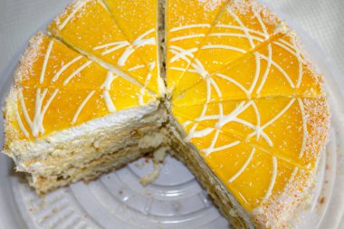 Bir parça sarı pasta, büyük beyaz tabakta yarım daire. pasta dilimleri