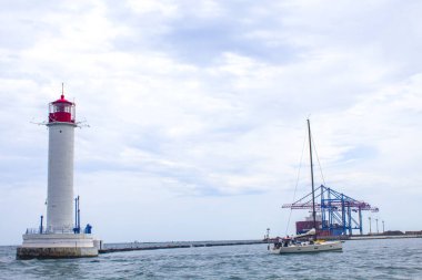 Güzel manzara. Mevcut deniz feneri. Odessa 'daki Vorontsov deniz fenerine karşı Karadeniz' in arka planı, yakın plan. Üzerinde mavi deniz manzaralı kırmızı bir kabin olan beyaz kule.