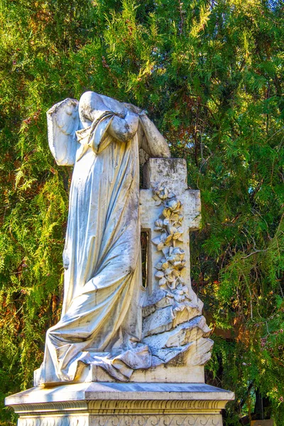 断头的跪天使雕像 双手交叉在蓝天和有十字架背景的墓碑上 — 图库照片