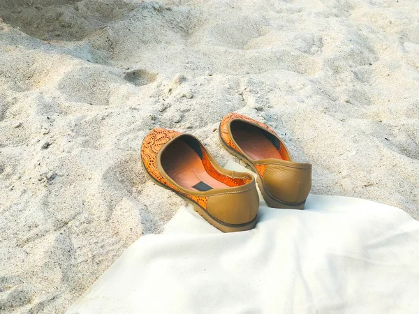 Women\'s beach shoes on sand. Summer holiday and vacation concept.
