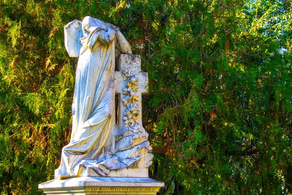 断头的跪天使雕像 双手交叉在蓝天和有十字架背景的墓碑上 — 图库照片