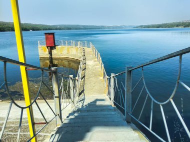 Nehirde uzun bir iskele Güzel mavi gökyüzünün altında.