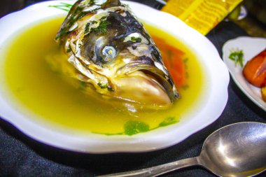 Tabakta balık kafası olan balık çorbası.