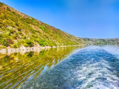 Dniester nehrinde beyaz iz, köpük ve dalgalar, geminin arkasında. Yolcu gemisi tarafından yaratılan su dalgaları.