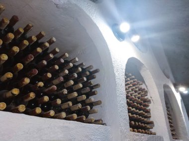 Şarap mahzenlerinde raflarda tozlu şarap şişeleri