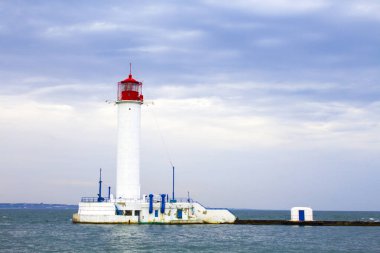 Güzel manzara. Mevcut deniz feneri. Odessa 'daki Vorontsov deniz fenerine karşı Karadeniz' in arka planı, yakın plan. Üzerinde mavi deniz manzaralı kırmızı bir kabin olan beyaz kule.