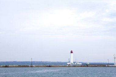 Güzel manzara. Mevcut deniz feneri. Odessa 'daki Vorontsov deniz fenerine karşı Karadeniz' in arka planı, yakın plan. Üzerinde mavi deniz manzaralı kırmızı bir kabin olan beyaz kule.