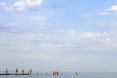 İnsanlar Karadeniz 'in sularının keyfini çıkarıyorlar. Birçok insan deniz suyunda yüzer. Karadeniz 'de tatil yapan turistler.
