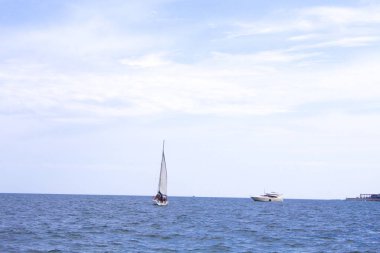 Okyanusta mavi okyanuslu beyaz yelkenli sahnesi